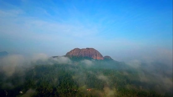 Kolagappara Rock monolith surrounded by lush greenery